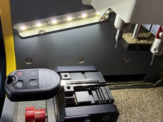 Key cutting machine inside the Top Tier Locksmith van cutting a Ford key blank