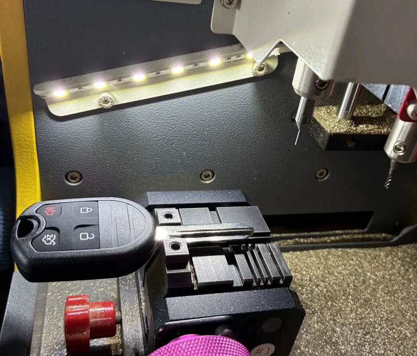 Key cutting machine inside the Top Tier Locksmith van cutting a Ford key blank