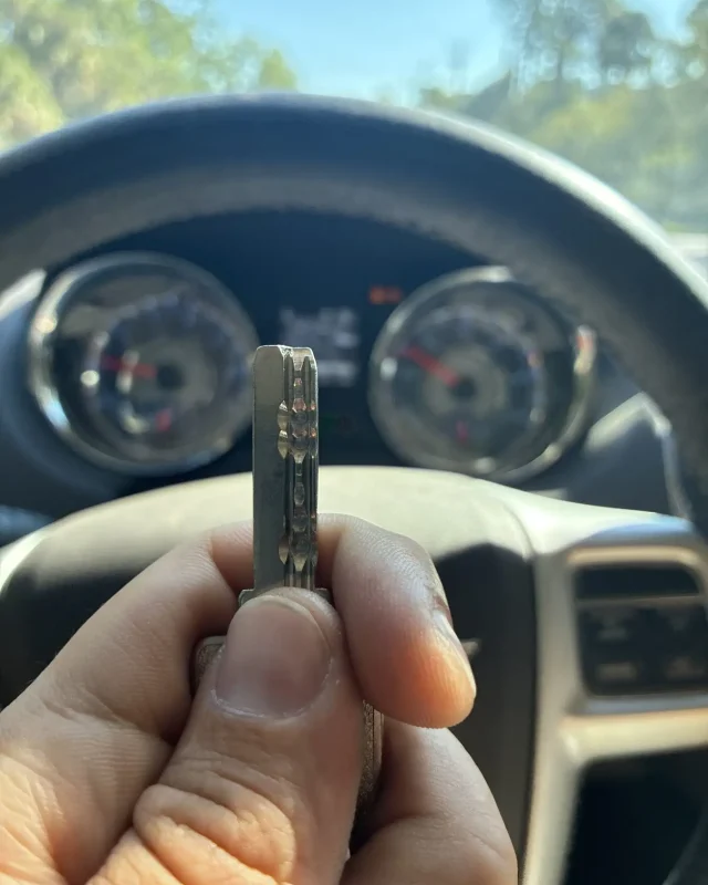 Freshly cut car key held up inside the customer's vehicle