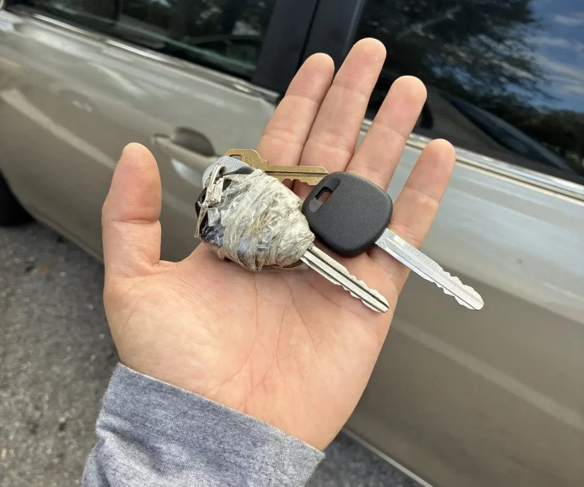 Worn original car key being replaced with a new cut and programmed key
